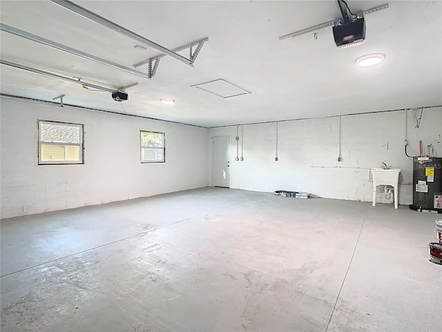 garage featuring electric water heater, a garage door opener, and a sink