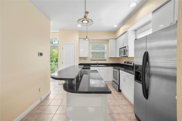 kitchen with a center island, decorative light fixtures, appliances with stainless steel finishes, white cabinetry, and a sink