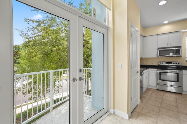 kitchen featuring dark countertops, white cabinets, a healthy amount of sunlight, and stainless steel appliances