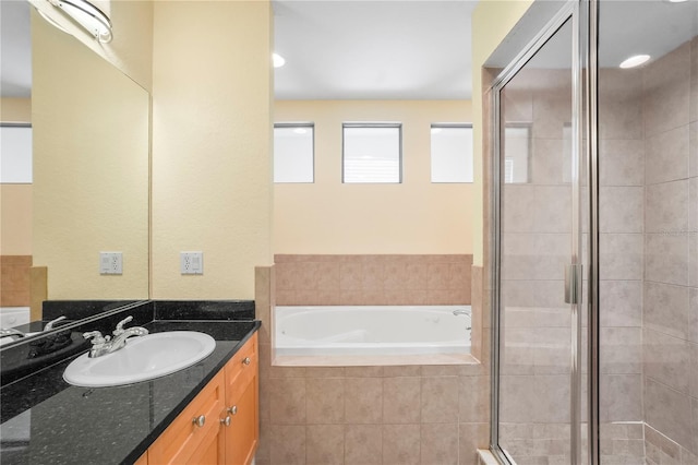 full bath with vanity, a garden tub, and a stall shower