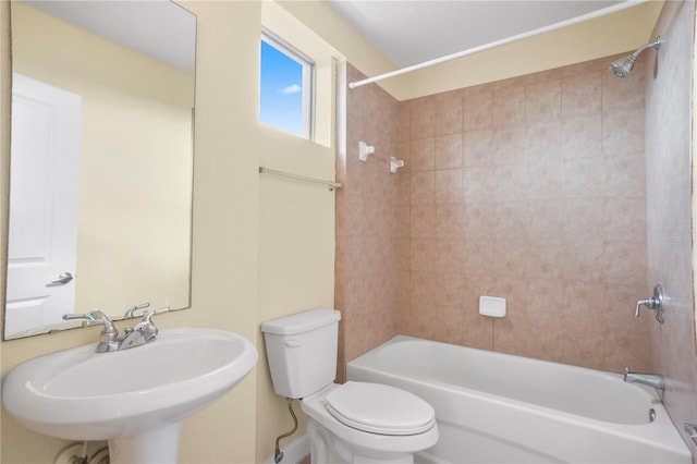 bathroom with a sink, shower / bathing tub combination, and toilet