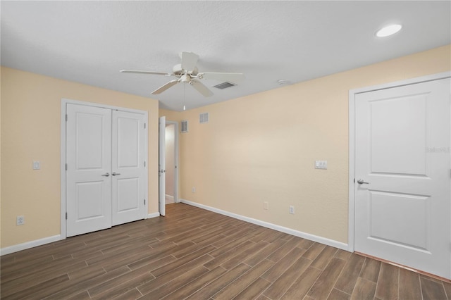 unfurnished bedroom with a closet, visible vents, baseboards, and wood tiled floor