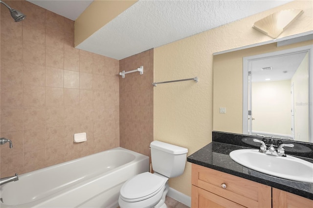 bathroom featuring toilet, shower / washtub combination, vanity, and a textured wall