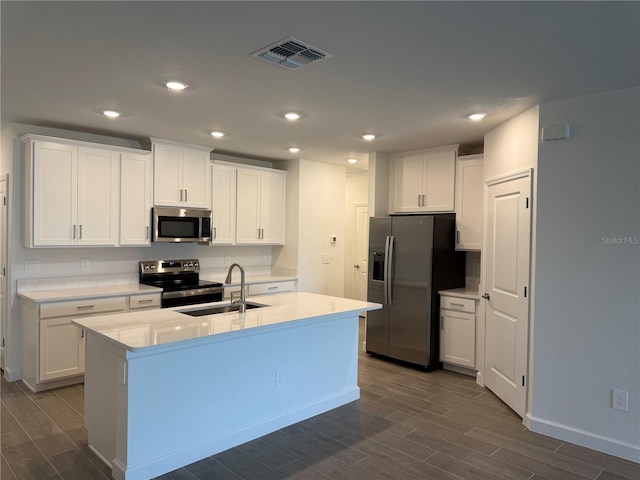 10578 Gable Dig Loop, San Antonio, FL 33576 - kitchen featuring a sink, stainless steel appliances, visible vents, white cabinetry, and dark wood finished floors