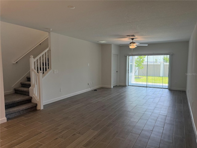 10578 Gable Dig Loop, San Antonio, FL 33576 - unfurnished living room with dark wood finished floors, stairs, ceiling fan, baseboards, and visible vents