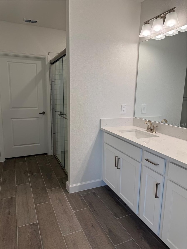 10578 Gable Dig Loop, San Antonio, FL 33576 - bathroom with a shower stall, wood tiled floor, visible vents, baseboards, and vanity