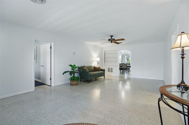 1005 Catalpa Ln, Orlando, FL 32806 - living room featuring arched walkways, baseboards, speckled floor, and a ceiling fan