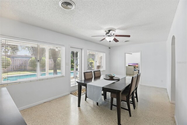 1005 Catalpa Ln, Orlando, FL 32806 - dining area with visible vents, light speckled floor, arched walkways, ceiling fan, and a textured ceiling