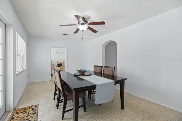 1005 Catalpa Ln, Orlando, FL 32806 - dining area featuring baseboards, a textured ceiling, a ceiling fan, light speckled floor, and arched walkways