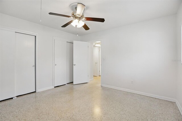1005 Catalpa Ln, Orlando, FL 32806 - unfurnished bedroom with multiple closets, light speckled floor, baseboards, and a ceiling fan