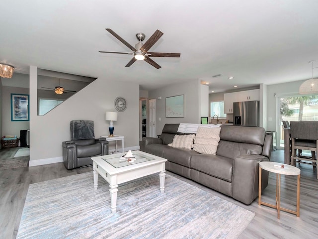 living area featuring light wood finished floors, recessed lighting, baseboards, and a ceiling fan