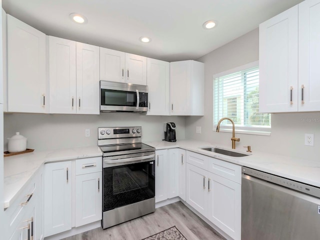 kitchen featuring recessed lighting, white cabinets, appliances with stainless steel finishes, and a sink