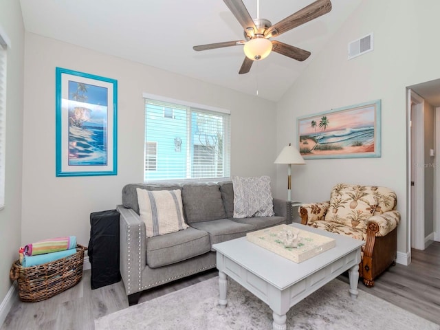 living room with visible vents, a ceiling fan, vaulted ceiling, and light wood finished floors