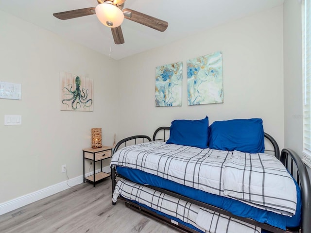 bedroom with a ceiling fan, light wood-type flooring, and baseboards