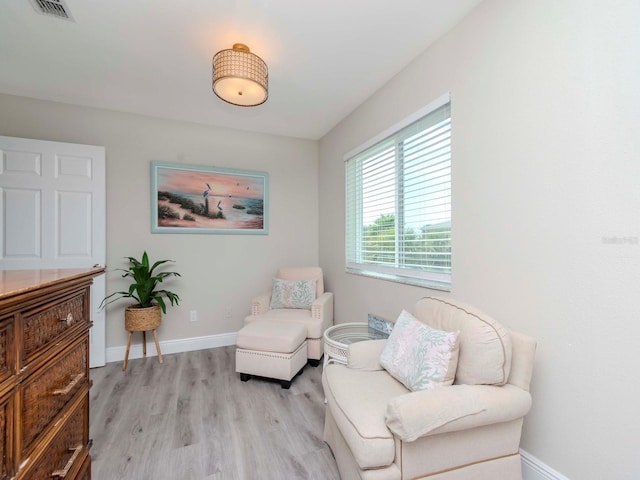 sitting room featuring visible vents, baseboards, and light wood-style flooring