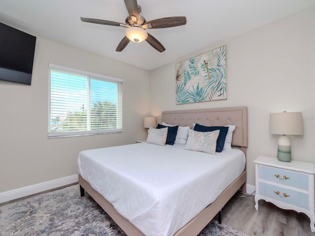 bedroom featuring ceiling fan, baseboards, and wood finished floors