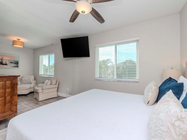 bedroom featuring light wood finished floors, baseboards, and ceiling fan