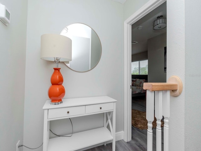 corridor with wood finished floors and baseboards