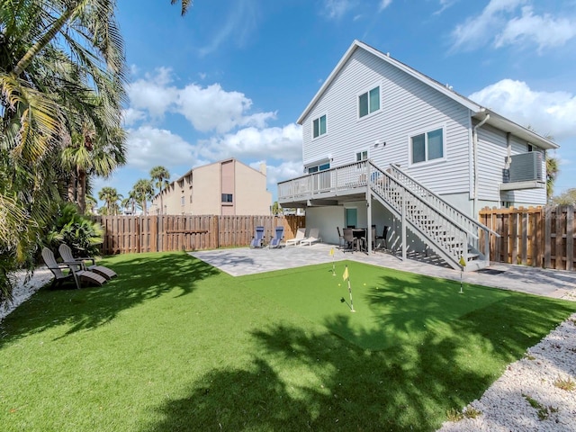 back of house with stairway, a patio, a lawn, and a fenced backyard