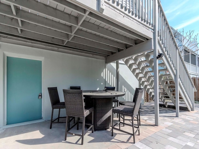 view of patio / terrace featuring outdoor dining area and stairway