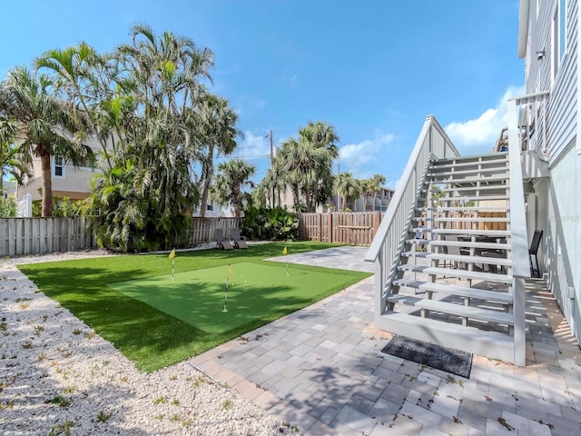 view of yard with stairs, a patio area, and a fenced backyard