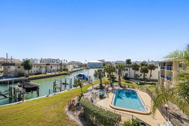 exterior space with a water view, a lawn, a boat dock, a patio, and boat lift