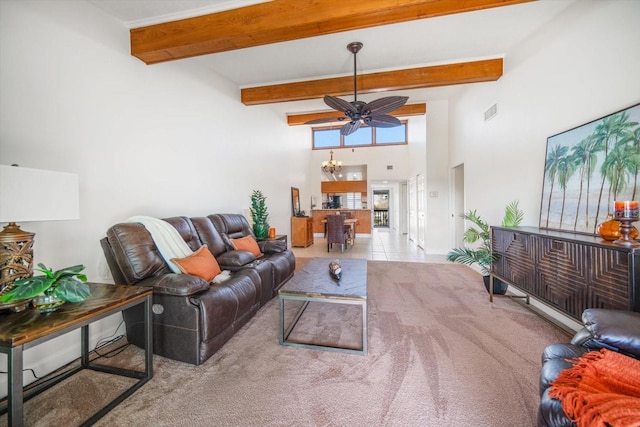 living room with tile patterned floors, beamed ceiling, visible vents, ceiling fan with notable chandelier, and a towering ceiling