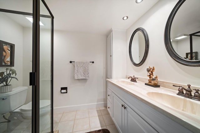 bathroom featuring tile patterned flooring, double vanity, toilet, and a sink