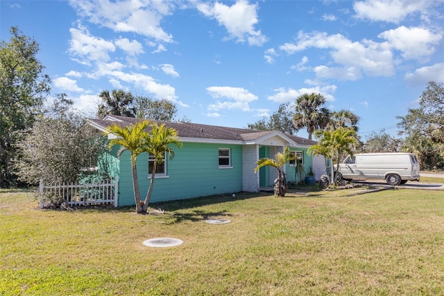 view of front of house with a front lawn and fence