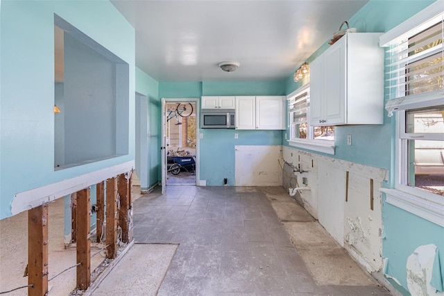 kitchen with white cabinetry and stainless steel microwave