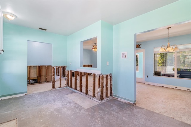 empty room with ceiling fan with notable chandelier, baseboards, and visible vents