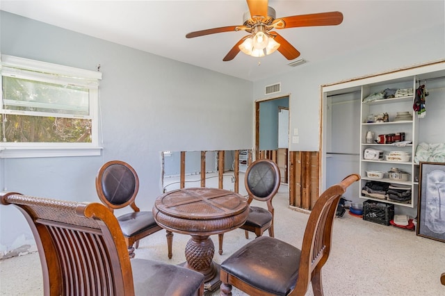 living area featuring visible vents and ceiling fan