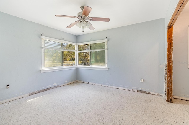 unfurnished room featuring a ceiling fan and speckled floor