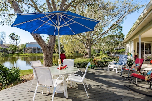 wooden terrace with outdoor dining area and a water view