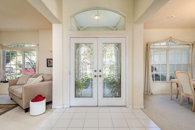 tiled entryway featuring carpet, french doors, and baseboards