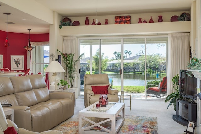 living room with visible vents, a water view, and carpet