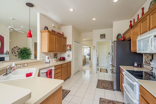 kitchen featuring a sink, white appliances, light countertops, light tile patterned floors, and ceiling fan