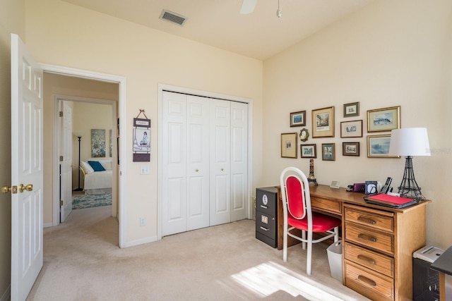 office featuring a ceiling fan, light colored carpet, and visible vents