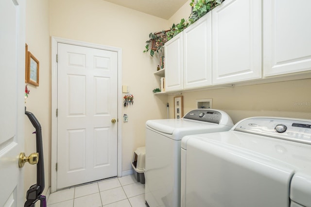 laundry room with light tile patterned floors, cabinet space, and washing machine and clothes dryer