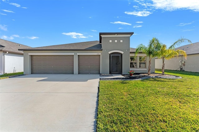 view of front of house with stucco siding, a front yard, concrete driveway, and an attached garage