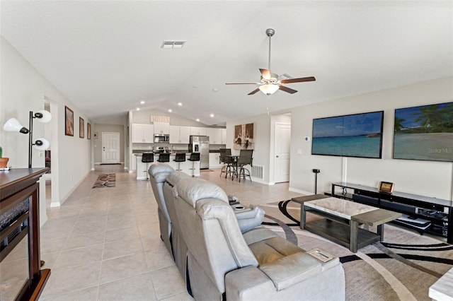 living area featuring light tile patterned floors, visible vents, a ceiling fan, and vaulted ceiling