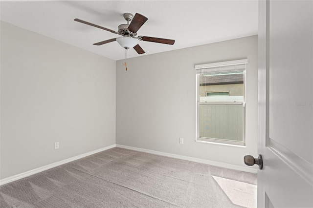 carpeted spare room with baseboards and ceiling fan