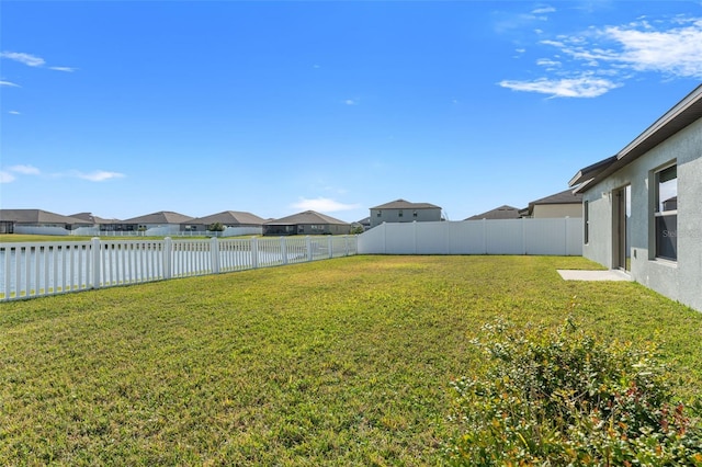 view of yard featuring a residential view and a fenced backyard