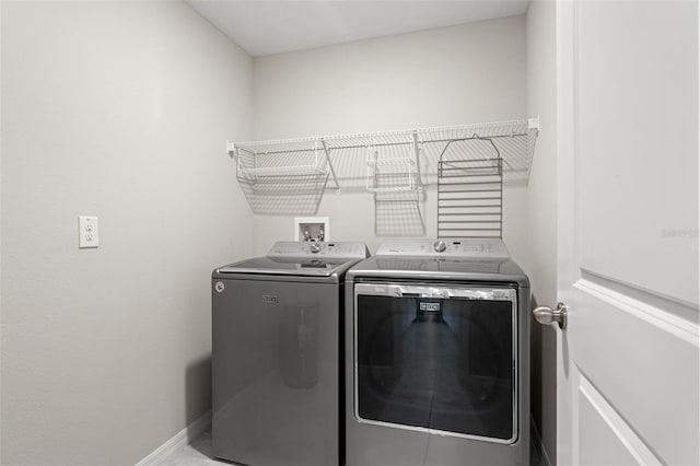 laundry area featuring laundry area, baseboards, and washer and clothes dryer