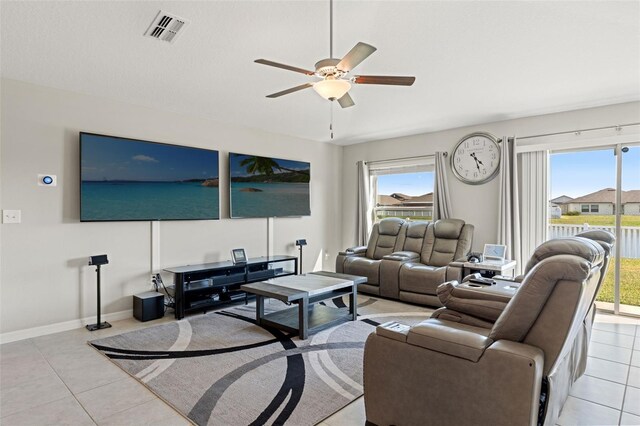 living area with visible vents, plenty of natural light, baseboards, and a ceiling fan