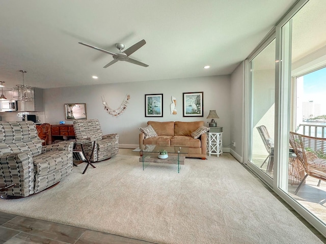 carpeted living room featuring expansive windows, recessed lighting, baseboards, and ceiling fan