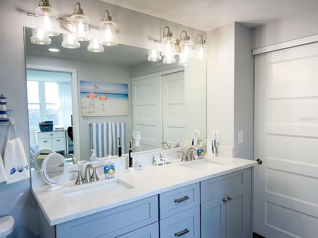 bathroom featuring a sink and double vanity