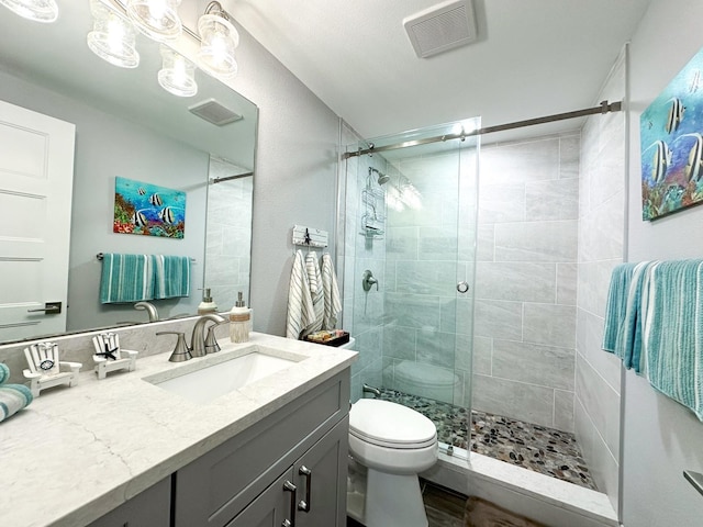 full bathroom featuring visible vents, vanity, toilet, and a shower stall