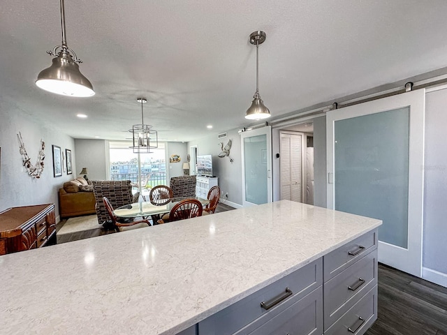 kitchen featuring dark wood-type flooring, decorative light fixtures, and gray cabinets