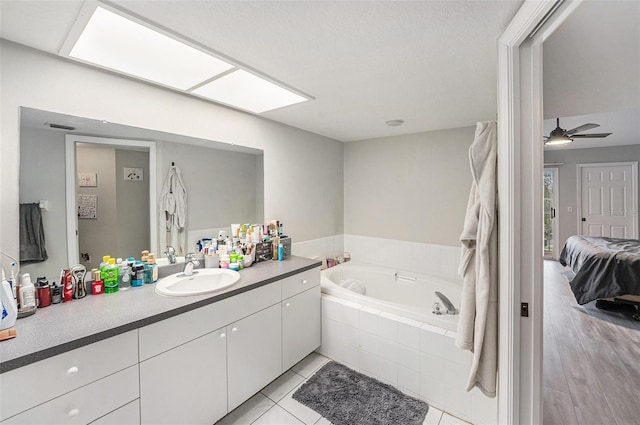 bathroom with vanity, a ceiling fan, ensuite bathroom, tile patterned floors, and a bath